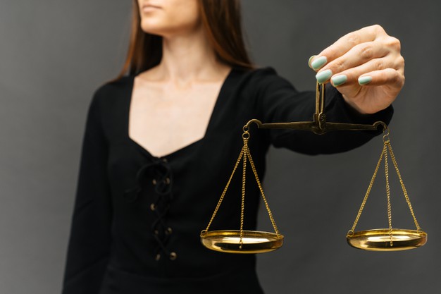 serious-woman-holding-justice-scale-dark-background_132310-1942